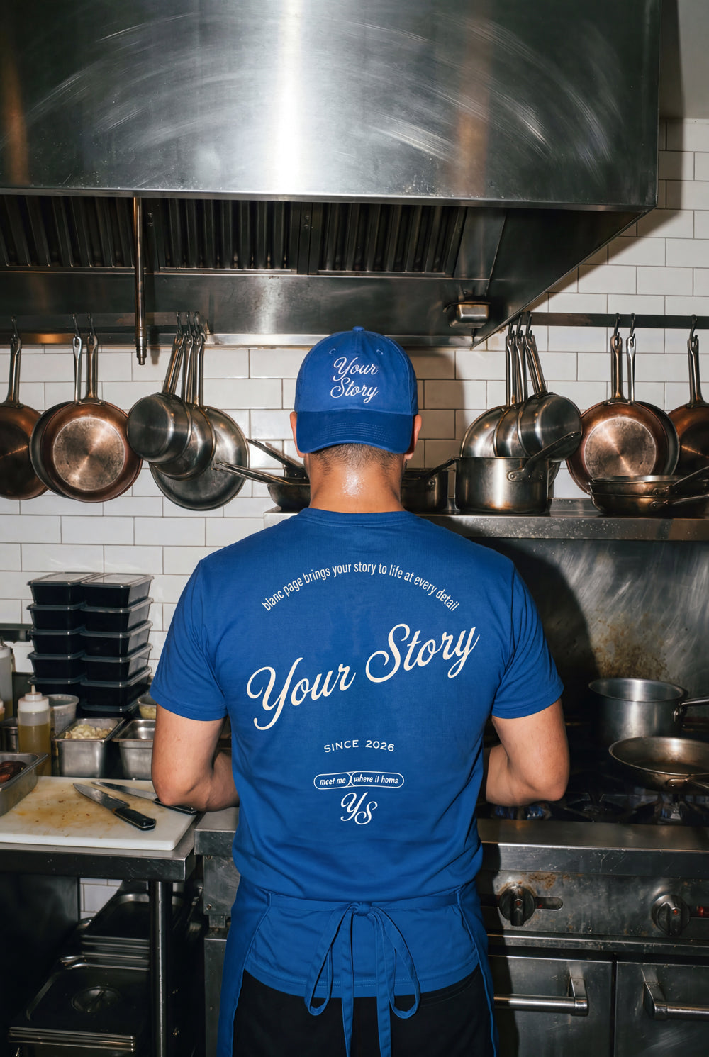 Person wearing a blue 'Your Story' t-shirt in a kitchen. Hospitality Branding that touches every point of your brand experience, with every detail the brand story is told