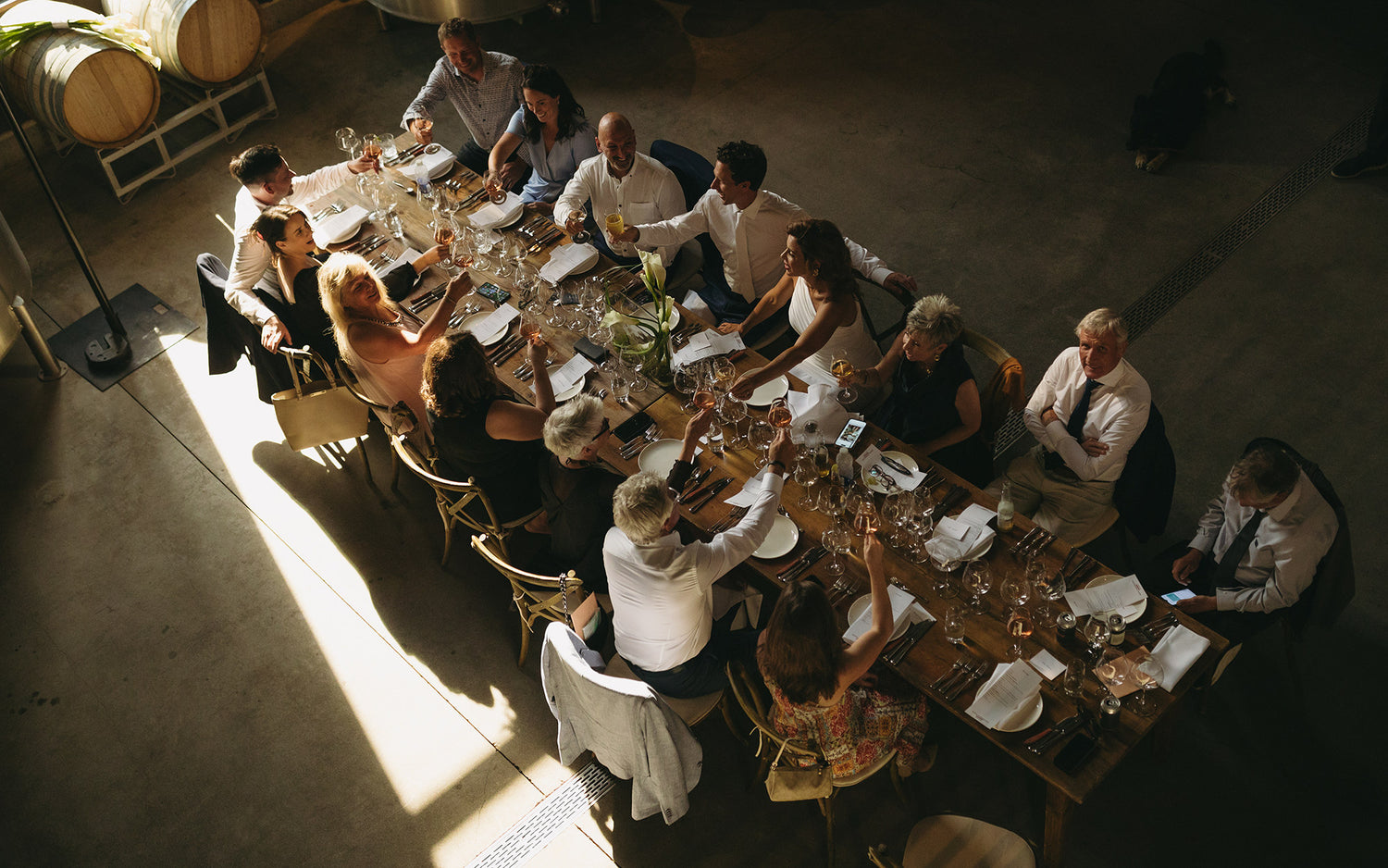 Group of people dining together at a long table in a warm, indoor setting - a unique hospitality experience provided by luxury hospitality and airbnb hosts.